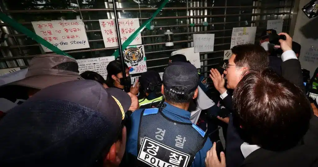 Man Arrested for Assaulting Police Amidst Protest at Ballot Box Site